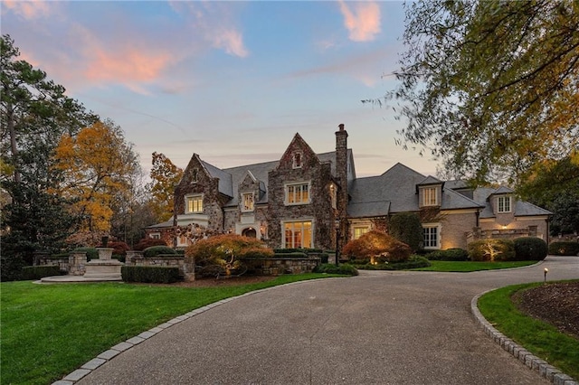 tudor home featuring a yard