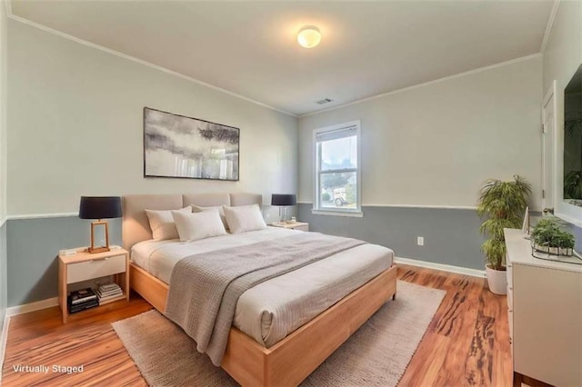 bedroom featuring baseboards, light wood finished floors, and ornamental molding