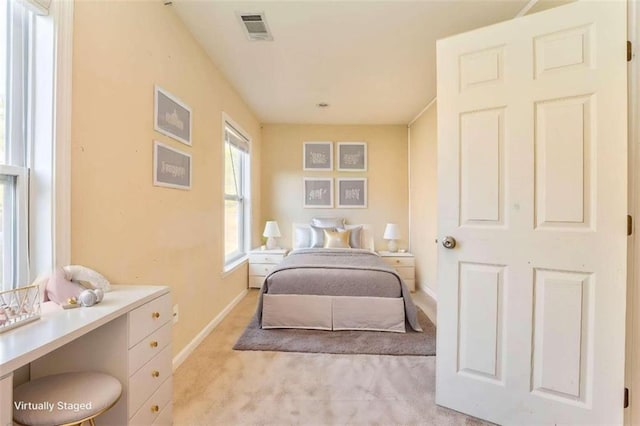 bedroom with visible vents, light colored carpet, and baseboards