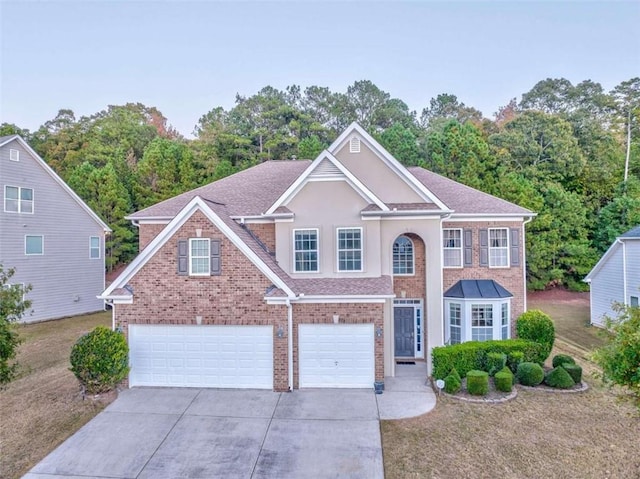 view of front of home with brick siding, an attached garage, and driveway