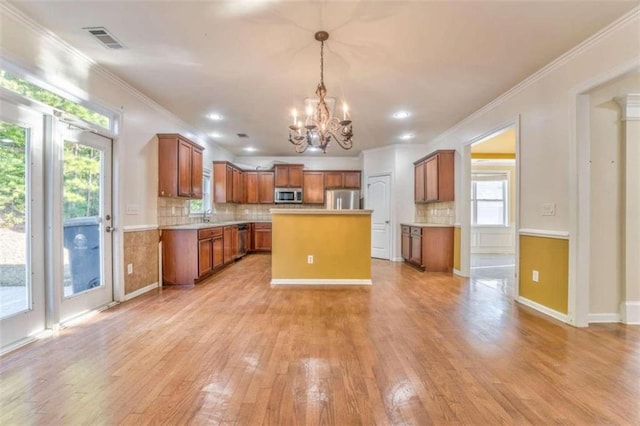 kitchen featuring visible vents, light wood-style flooring, appliances with stainless steel finishes, brown cabinetry, and a chandelier
