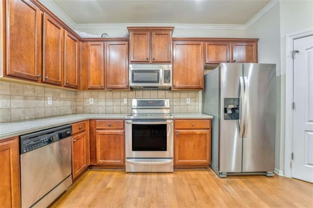 kitchen featuring brown cabinets, appliances with stainless steel finishes, light wood-type flooring, and light countertops