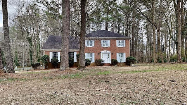 colonial house featuring brick siding