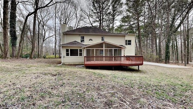 back of house with a sunroom and a chimney