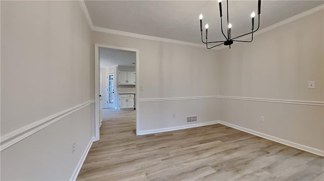 unfurnished dining area with baseboards, visible vents, an inviting chandelier, crown molding, and light wood-style floors