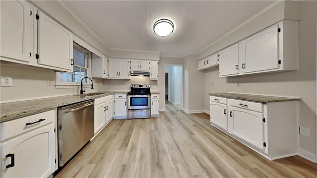 kitchen with appliances with stainless steel finishes, ornamental molding, white cabinetry, a sink, and under cabinet range hood