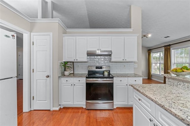 kitchen with stainless steel electric range oven, freestanding refrigerator, under cabinet range hood, light wood finished floors, and backsplash