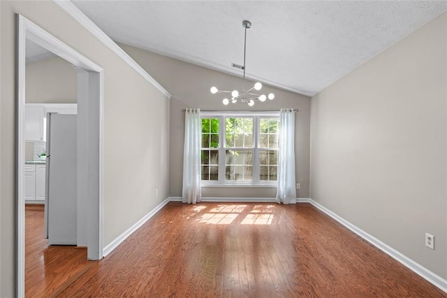 unfurnished dining area featuring vaulted ceiling, wood finished floors, a chandelier, and baseboards