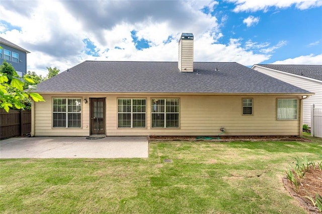 rear view of house featuring a chimney, a patio, and roof with shingles