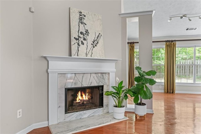 detailed view of a fireplace, wood finished floors, and baseboards