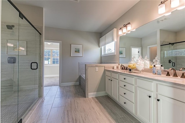 bathroom featuring a shower with shower door and double sink vanity