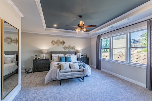 bedroom featuring ceiling fan, crown molding, light colored carpet, and a tray ceiling