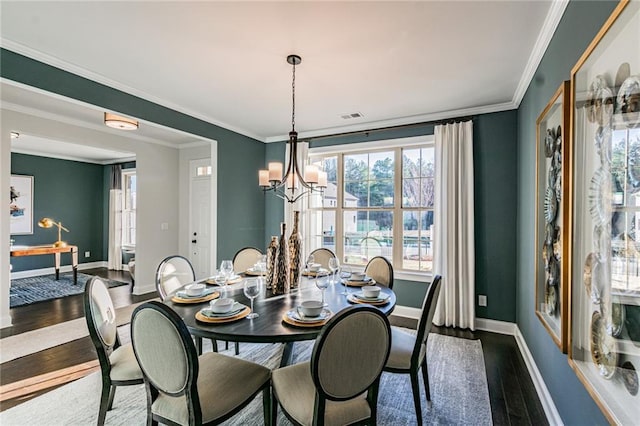 dining room with dark hardwood / wood-style floors, an inviting chandelier, and ornamental molding