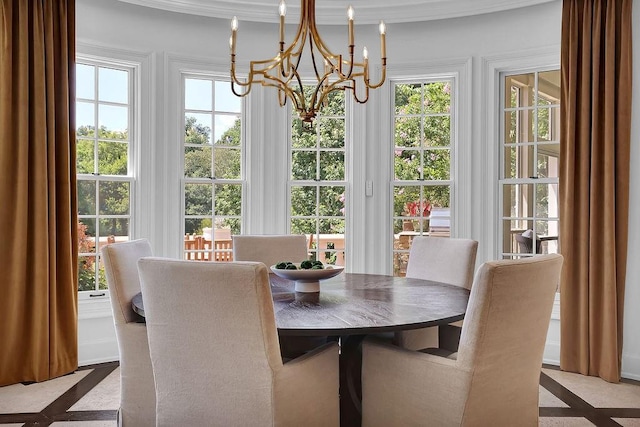 dining room featuring plenty of natural light, crown molding, and an inviting chandelier