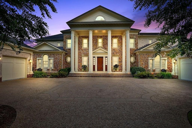 greek revival inspired property featuring a garage