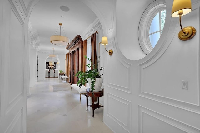 hallway with crown molding and light tile floors