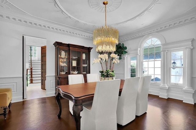 dining room featuring crown molding, an inviting chandelier, and dark parquet floors