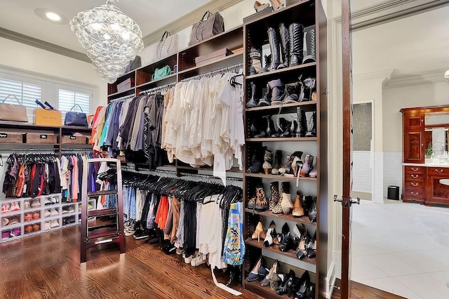 spacious closet featuring a notable chandelier and hardwood / wood-style flooring