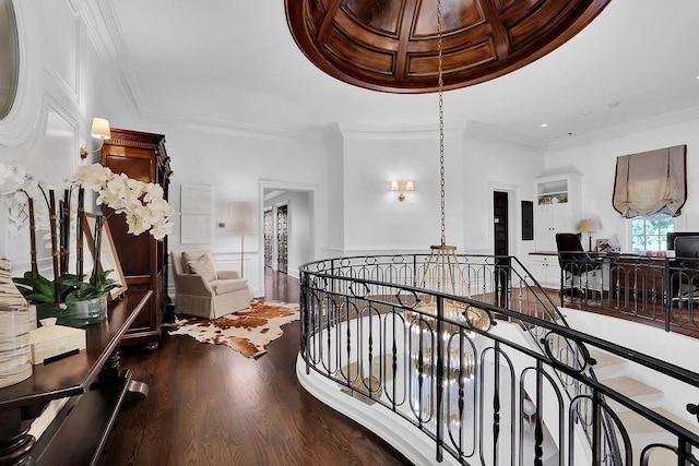 hall with ornamental molding, coffered ceiling, dark hardwood / wood-style floors, and a chandelier