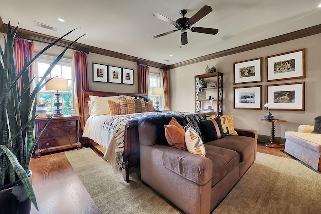 bedroom featuring ceiling fan, crown molding, and light hardwood / wood-style flooring