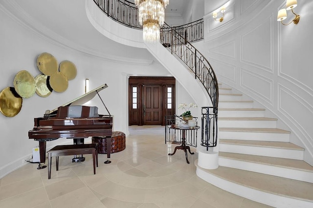 tiled entrance foyer with a high ceiling, a notable chandelier, and crown molding