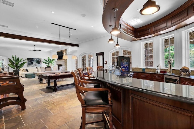 bar featuring decorative light fixtures, ceiling fan, light tile flooring, dark stone countertops, and beverage cooler