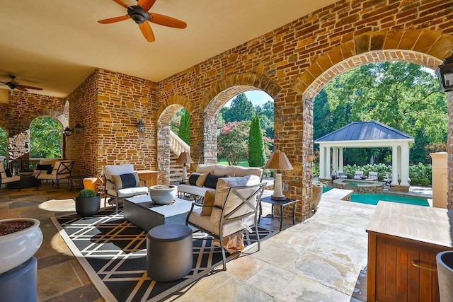 view of patio / terrace featuring an outdoor living space, ceiling fan, and a gazebo