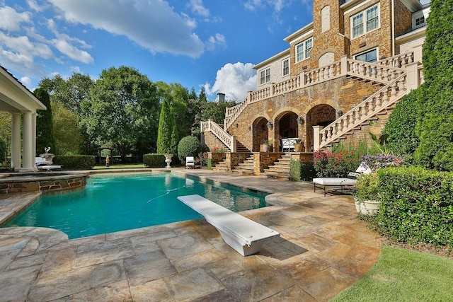 view of pool featuring a patio area and a diving board