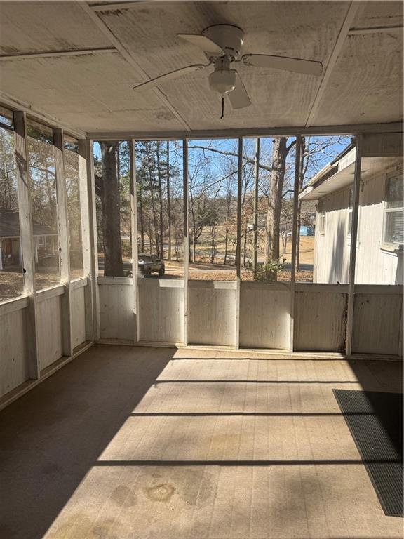 unfurnished sunroom featuring ceiling fan