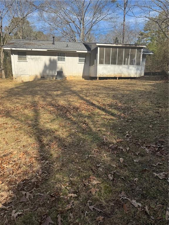 back of house with a lawn and a sunroom