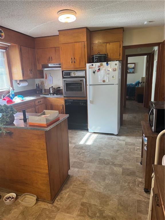 kitchen featuring stainless steel appliances, kitchen peninsula, and a textured ceiling