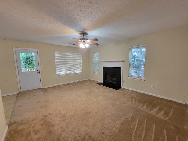 180 Preston Oaks Dr, Johns Creek, GA 30022 - unfurnished living room featuring light colored carpet, a ceiling fan, plenty of natural light, a fireplace with flush hearth, and a textured ceiling