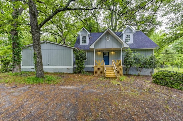 view of front of house with a shingled roof, a porch, and board and batten siding