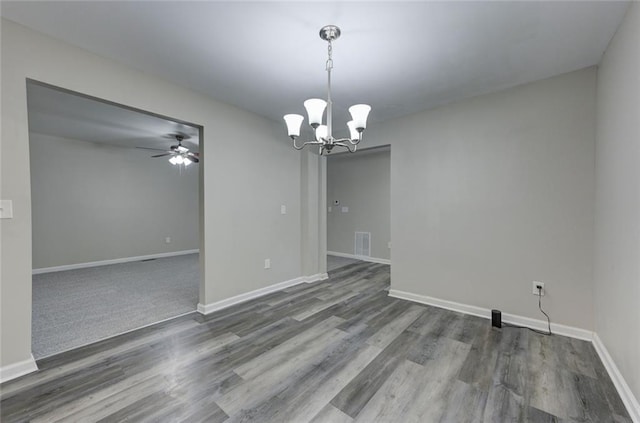empty room with a ceiling fan, a chandelier, baseboards, and wood finished floors