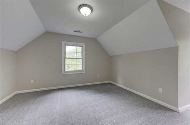 additional living space with carpet, baseboards, and vaulted ceiling