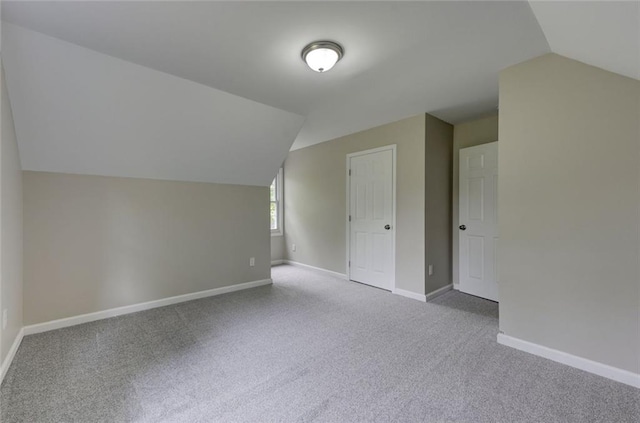 additional living space with lofted ceiling, carpet flooring, and baseboards