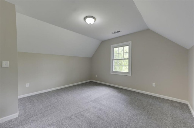 additional living space featuring carpet, vaulted ceiling, and baseboards