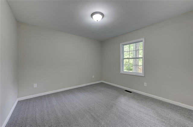carpeted spare room featuring baseboards
