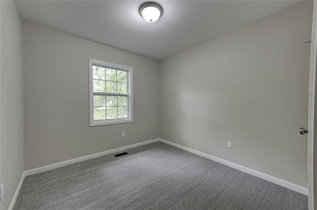 carpeted empty room featuring baseboards