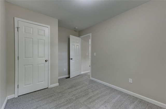 unfurnished bedroom with carpet floors and baseboards