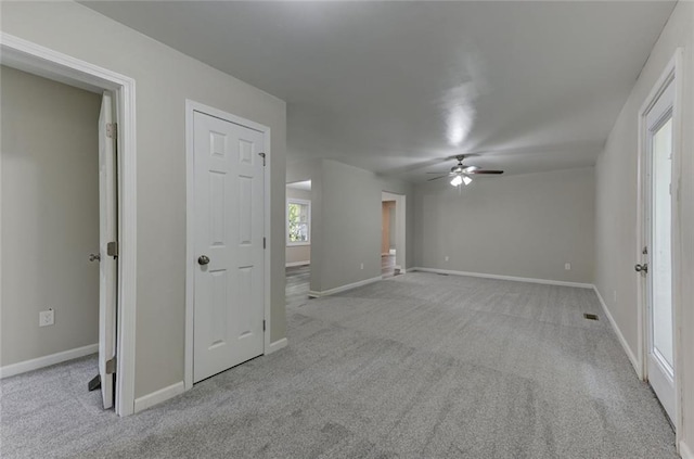 unfurnished room featuring ceiling fan, carpet flooring, and baseboards