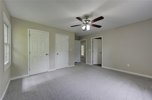 unfurnished bedroom with carpet, baseboards, and ceiling fan