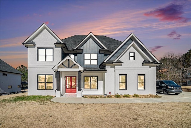 view of front of house with a front yard, french doors, and brick siding