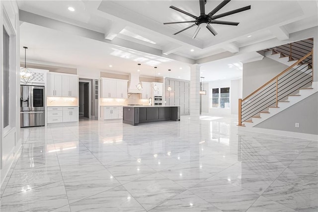 unfurnished living room featuring coffered ceiling, stairway, marble finish floor, beam ceiling, and ceiling fan with notable chandelier