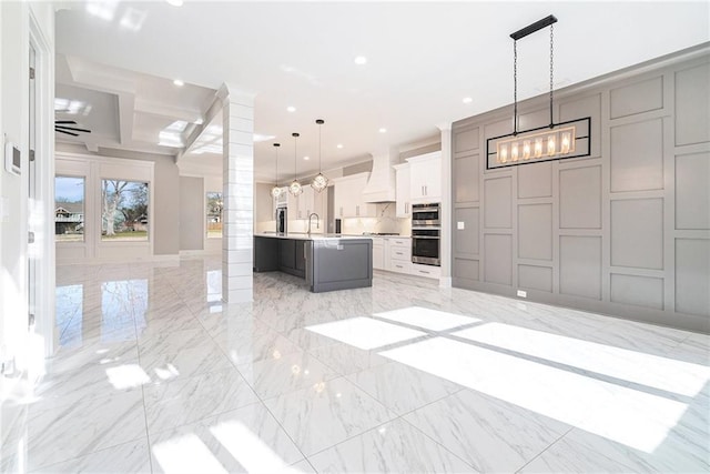 unfurnished living room featuring marble finish floor, a decorative wall, and recessed lighting
