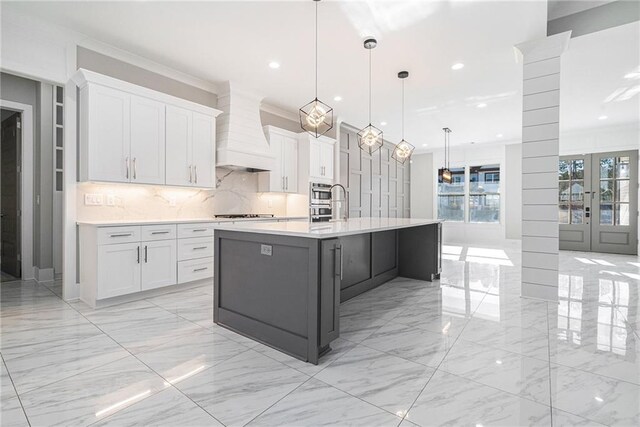 kitchen featuring light countertops, white cabinets, and premium range hood