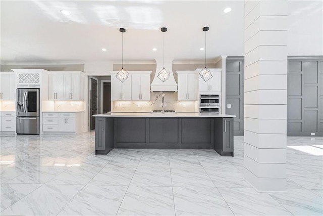 kitchen featuring white cabinets, decorative backsplash, appliances with stainless steel finishes, light countertops, and premium range hood