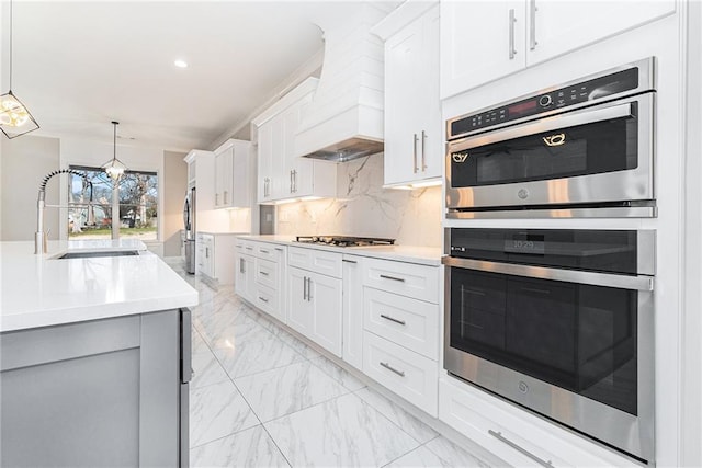 kitchen featuring stainless steel appliances, a sink, marble finish floor, decorative backsplash, and custom range hood