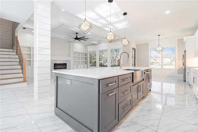 kitchen with marble finish floor, gray cabinetry, freestanding refrigerator, a sink, and ceiling fan