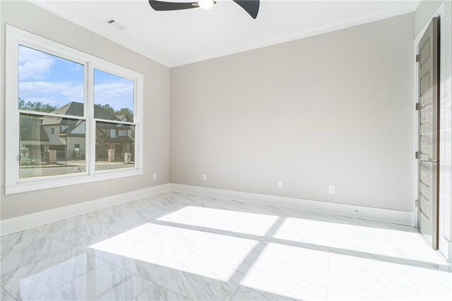 spare room featuring marble finish floor, visible vents, ornamental molding, ceiling fan, and baseboards